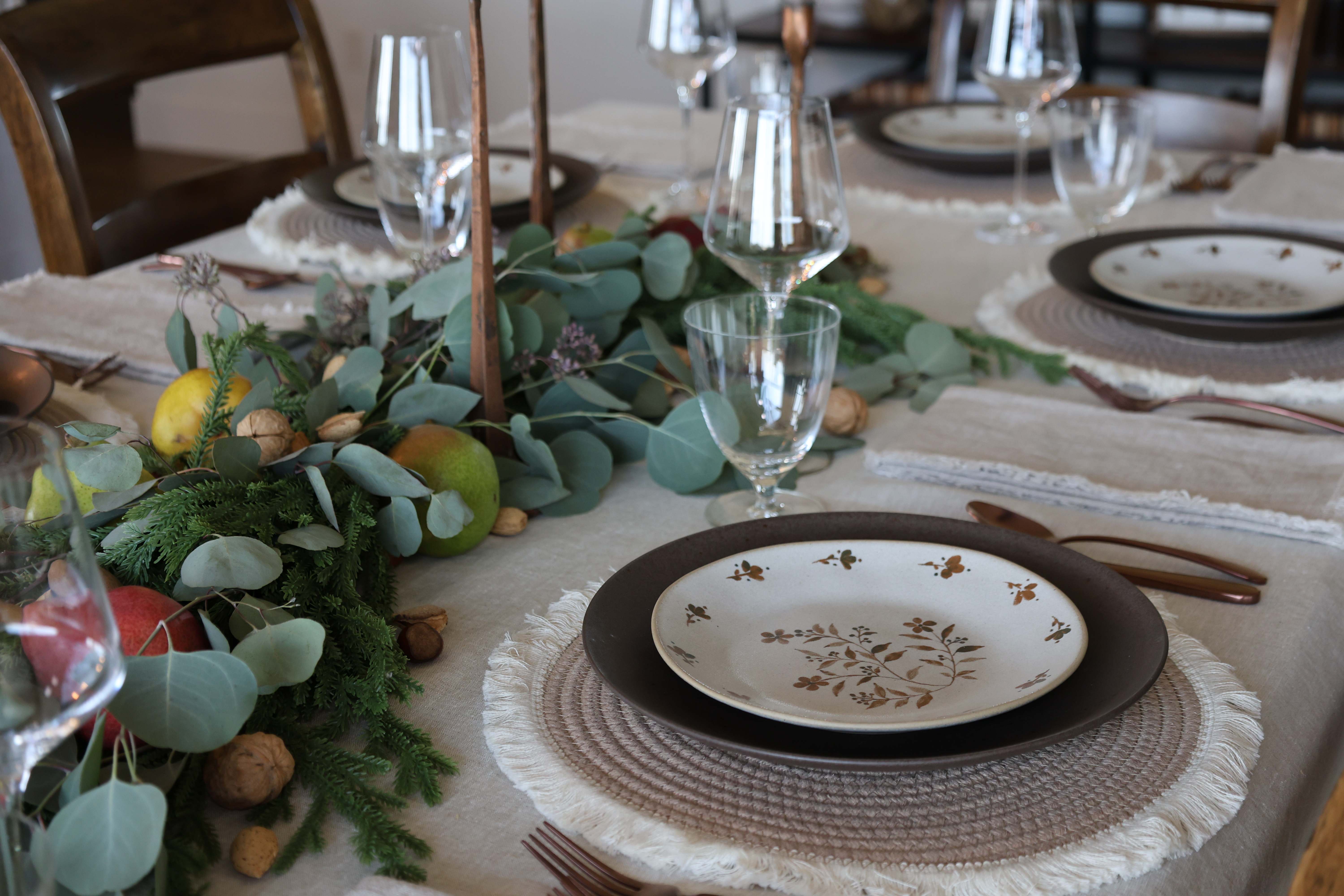 Elegant dinner gathering with eucalyptus centerpiece and vintage plates